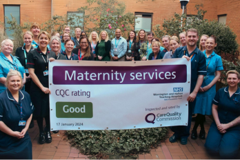 Members of the maternity team with a large banner displaying the Care Quality Commission 'Good' rating